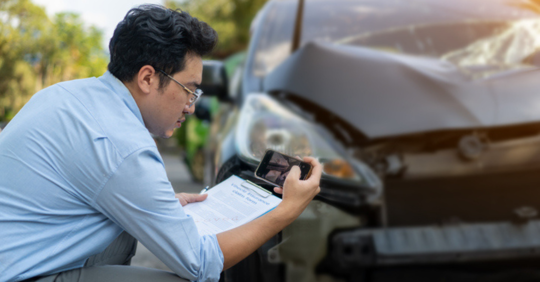 Man taking photo of car damage